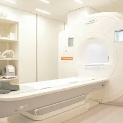Nowoczesny aparat do rezonansu magnetycznego z kontrastem, gotowy do badań. Na półkach sprzęt medyczny.