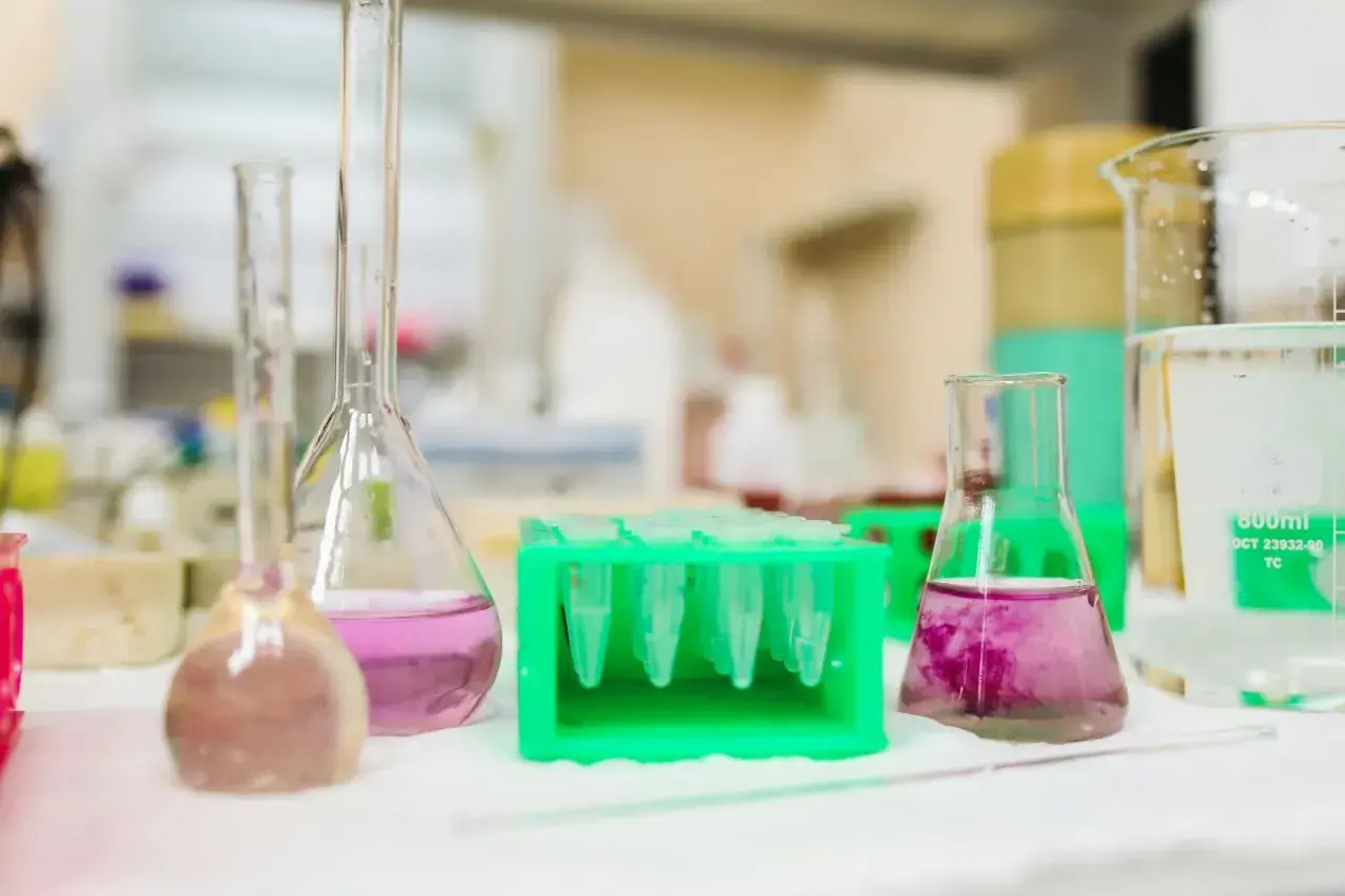 Kolby i probówki z kolorowymi płynami w laboratorium.